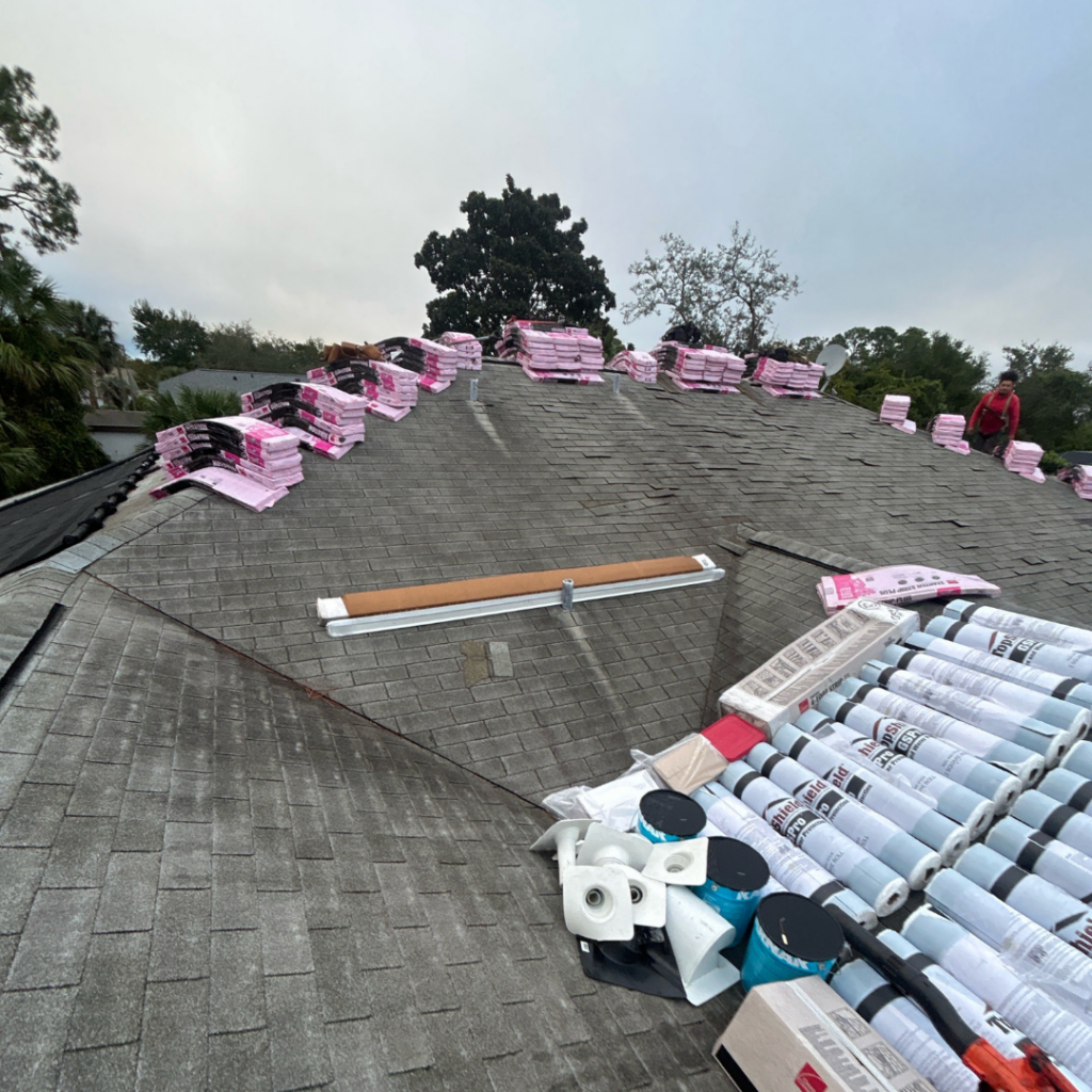 Roof replacement materials staged on shingle roof by AK Certified Roofing