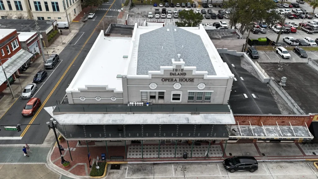 Drone view of commercial roofing project in DeLand with shingle roof, flat roof, and roof coating